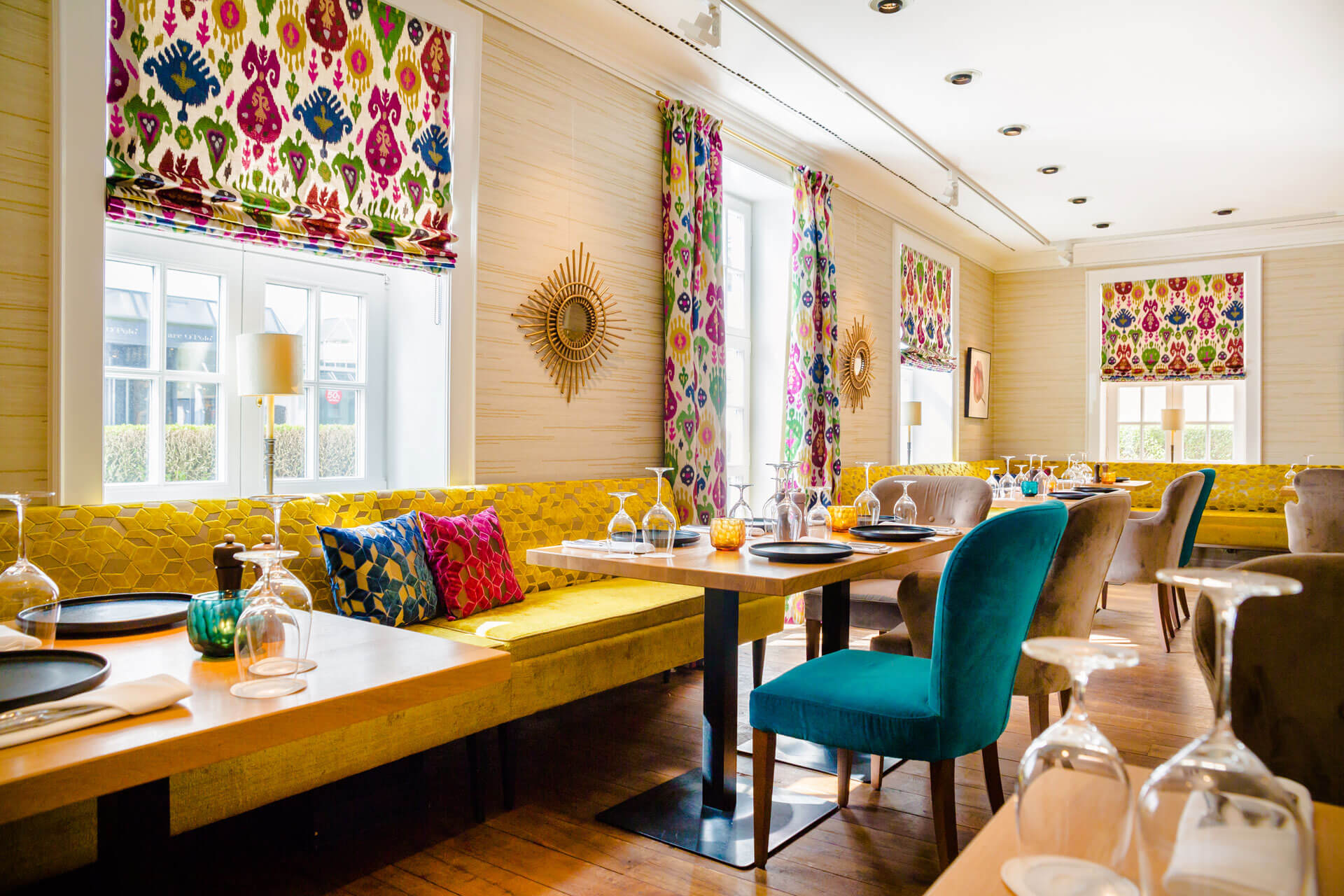 Ein buntes Restaurant mit Kissen und Tischen